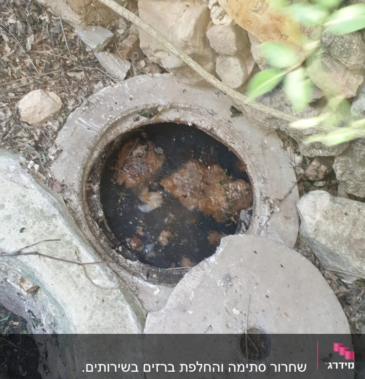 פתח ביוב פתוח עם מכסה בטון בצד